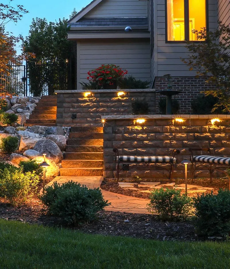 Hardscape wall and path lighting on stone retaining walls at dusk
